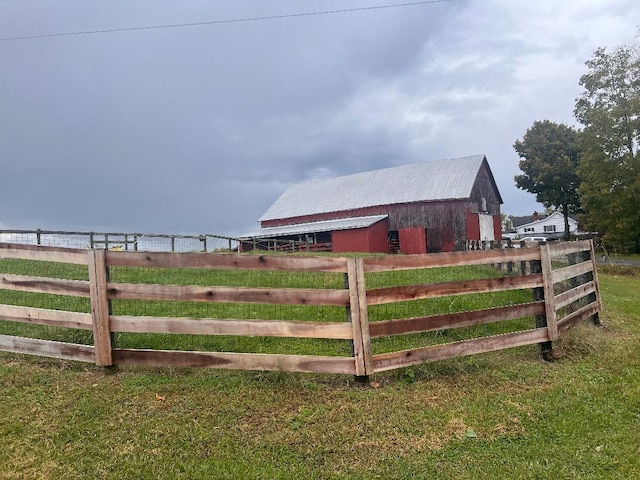 view of yard with a barn, fence, and an outdoor structure