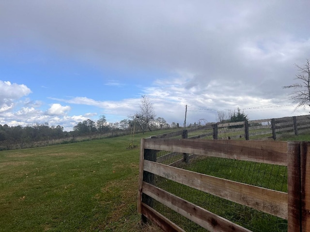 view of gate featuring a yard, fence, and a rural view