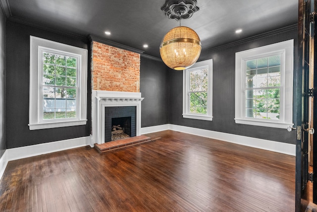 unfurnished living room with a brick fireplace, ornamental molding, and dark wood-type flooring