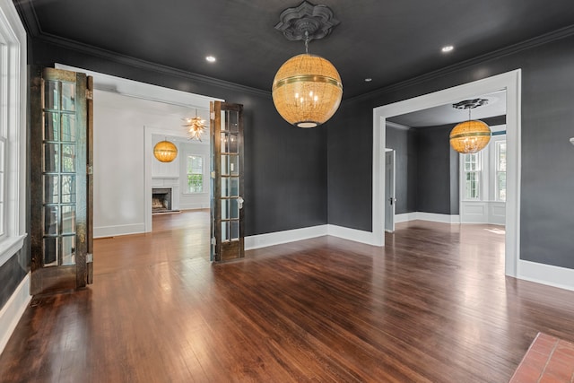 unfurnished dining area with dark hardwood / wood-style floors, ornamental molding, and plenty of natural light