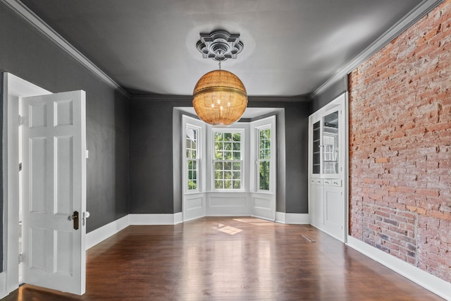 unfurnished dining area with dark hardwood / wood-style floors, brick wall, and ornamental molding