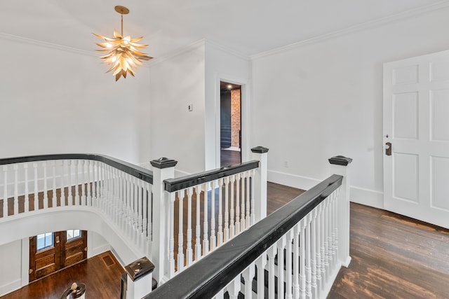 corridor with ornamental molding, a chandelier, and dark hardwood / wood-style flooring