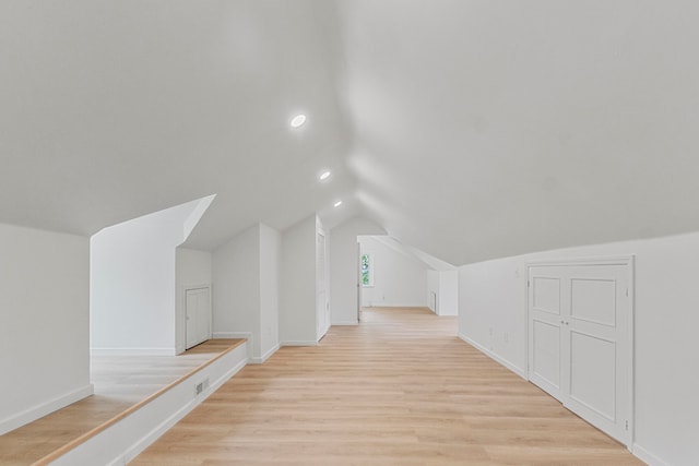 bonus room with lofted ceiling and light hardwood / wood-style flooring