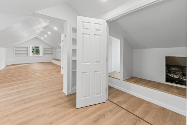 bonus room featuring light wood-type flooring and lofted ceiling