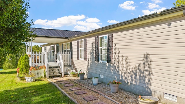 view of side of property featuring a yard and a wooden deck