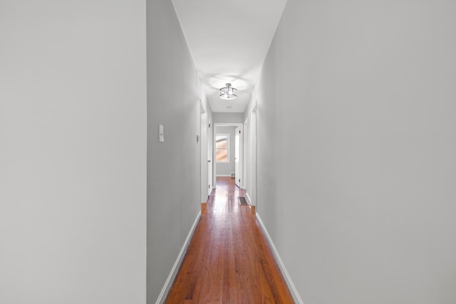 hallway with hardwood / wood-style floors