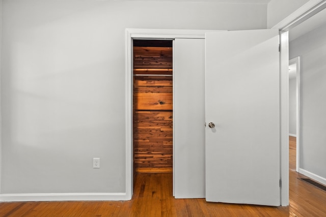 unfurnished bedroom with a closet and wood-type flooring