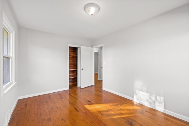 unfurnished bedroom featuring wood-type flooring and a closet