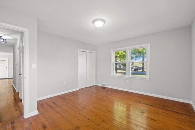 unfurnished bedroom with a closet and hardwood / wood-style flooring