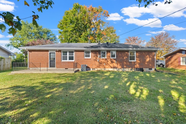 rear view of property featuring a lawn