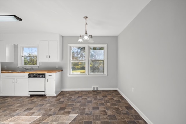 kitchen with white cabinets, white dishwasher, pendant lighting, butcher block countertops, and a notable chandelier