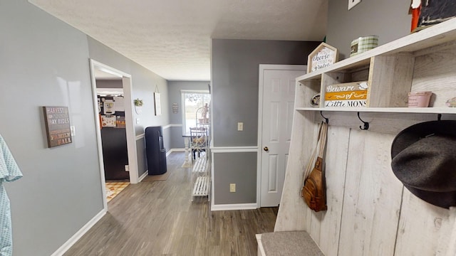 mudroom featuring wood-type flooring and a textured ceiling