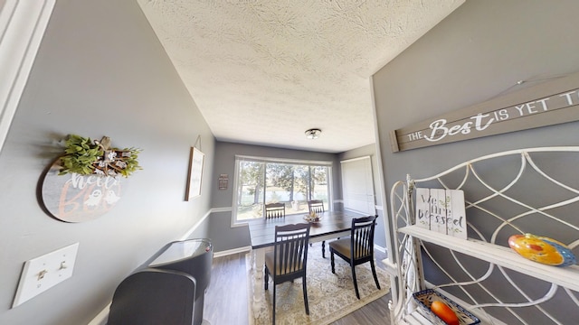 dining area featuring a textured ceiling and hardwood / wood-style flooring