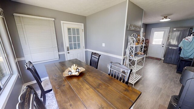 dining space with a textured ceiling and hardwood / wood-style flooring