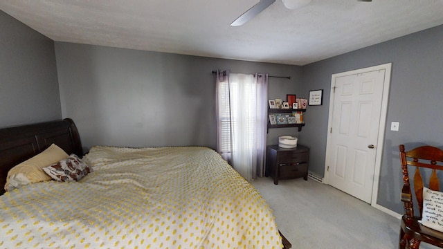 bedroom with a textured ceiling, light colored carpet, and ceiling fan