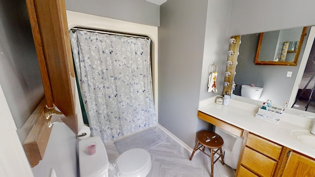 bathroom with vanity, toilet, parquet flooring, and curtained shower