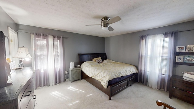 carpeted bedroom with a textured ceiling and ceiling fan