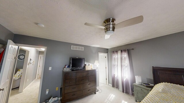 carpeted bedroom featuring a textured ceiling and ceiling fan