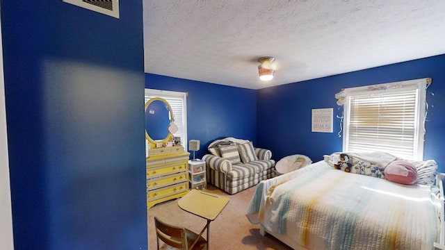 carpeted bedroom featuring a textured ceiling and ceiling fan