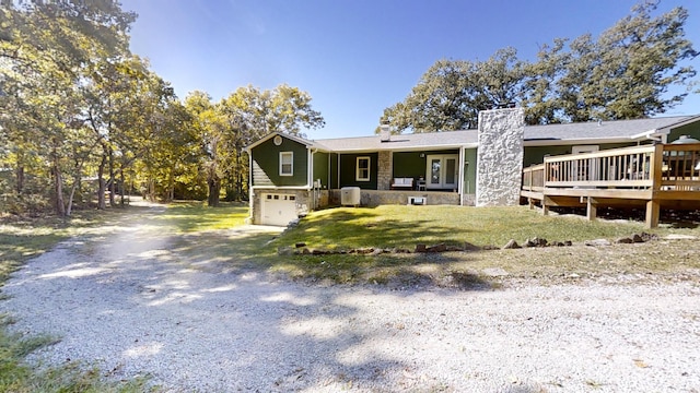 view of front of house featuring a deck, a front yard, and a garage