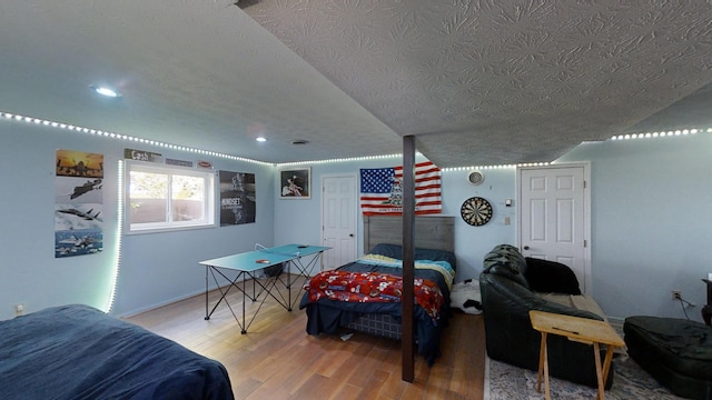 bedroom with hardwood / wood-style flooring and a textured ceiling