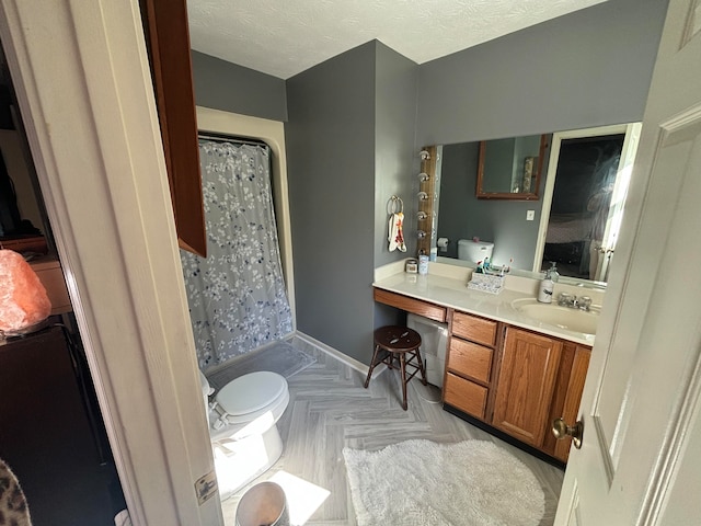 bathroom featuring vanity, a textured ceiling, toilet, and walk in shower