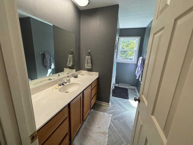 bathroom featuring vanity, a textured ceiling, and parquet flooring