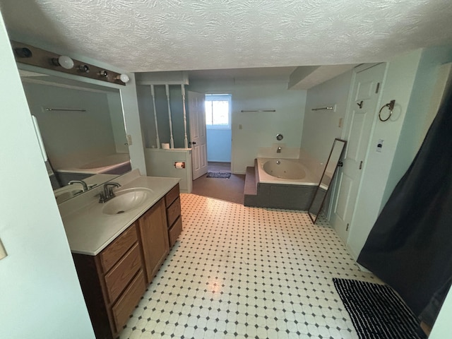 bathroom with vanity, a tub, and a textured ceiling