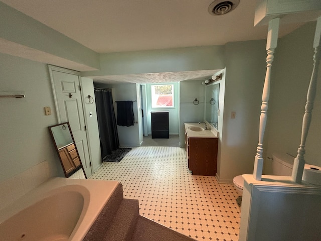 bathroom with vanity, a bathtub, and toilet