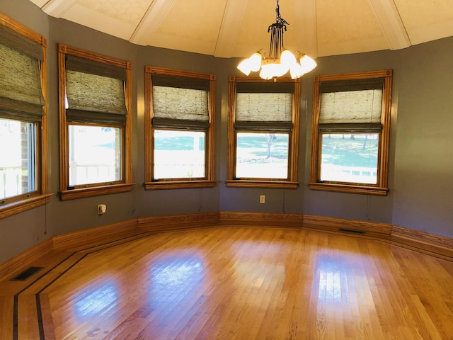 interior space featuring a healthy amount of sunlight, a chandelier, and light hardwood / wood-style floors