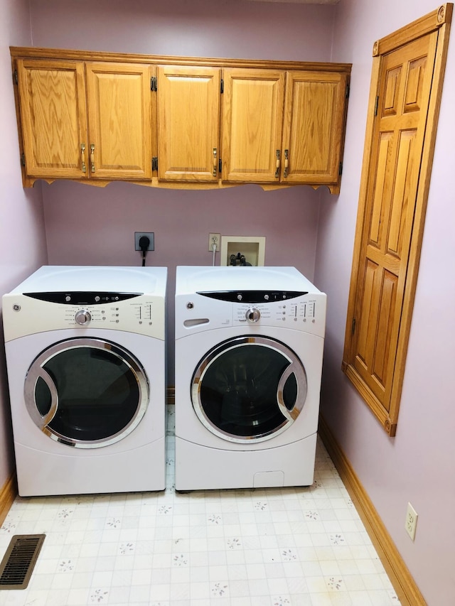 washroom with cabinets and washing machine and dryer