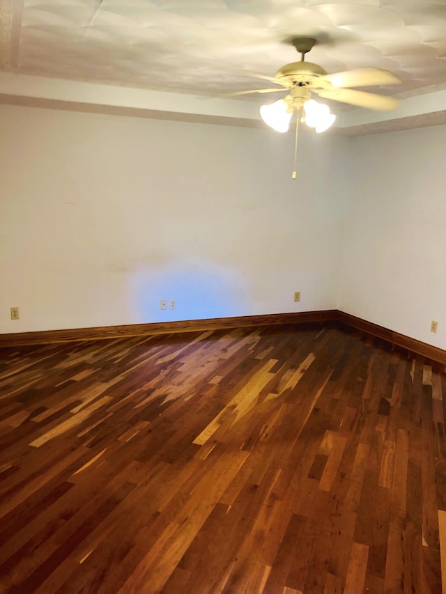 spare room featuring ceiling fan and dark hardwood / wood-style flooring