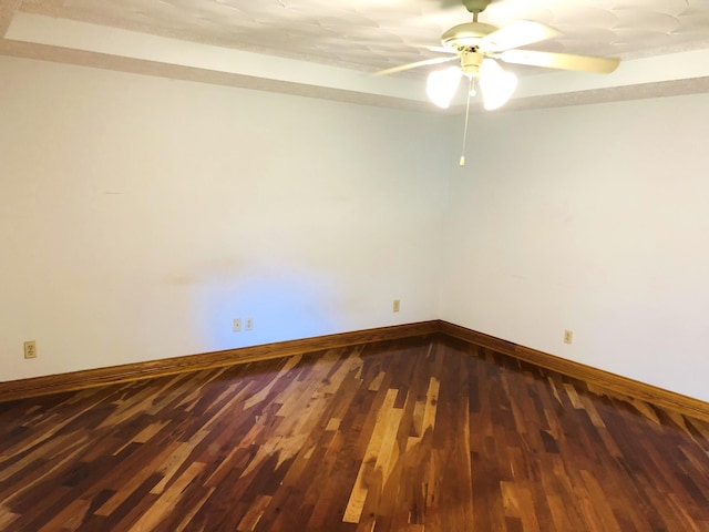 empty room with ceiling fan and dark hardwood / wood-style flooring