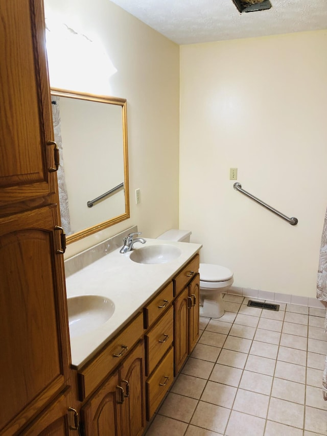 bathroom featuring tile patterned floors, toilet, and vanity