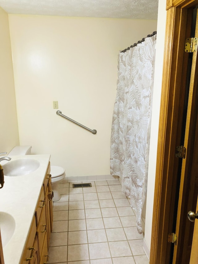 bathroom with vanity, tile patterned floors, a textured ceiling, and toilet