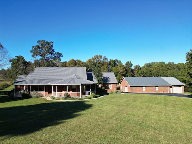 view of front of home with a garage, a front lawn, and a porch