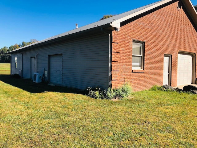 view of home's exterior with a garage, a yard, and ac unit