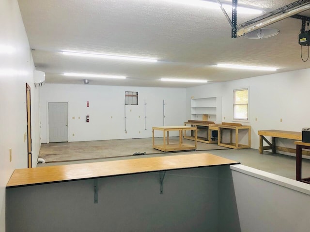 interior space featuring concrete flooring, a wall mounted air conditioner, and a textured ceiling