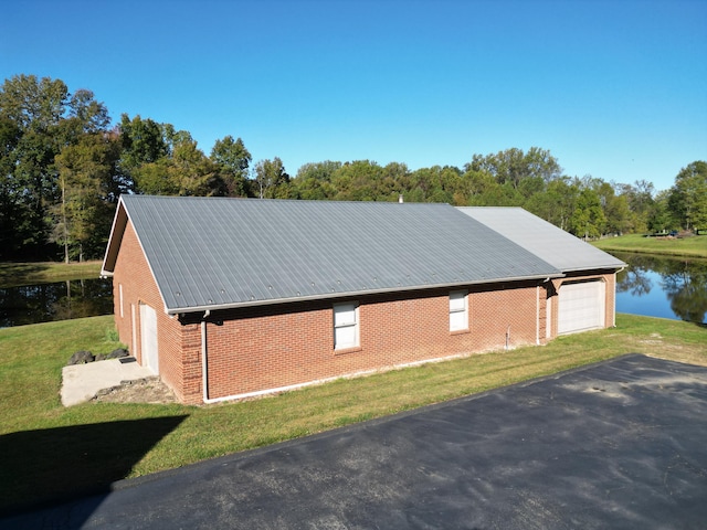 view of side of property with a lawn and a water view