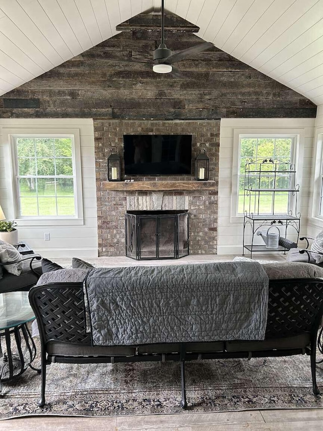 living room with a brick fireplace, hardwood / wood-style floors, wooden ceiling, vaulted ceiling, and wood walls