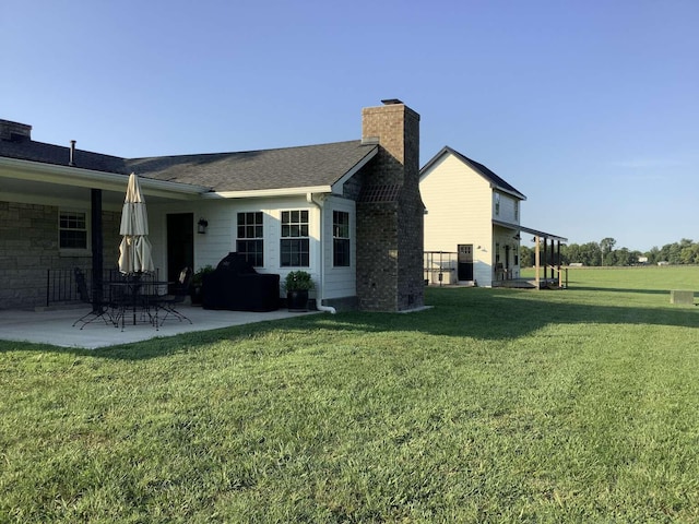 back of house with a lawn and a patio area