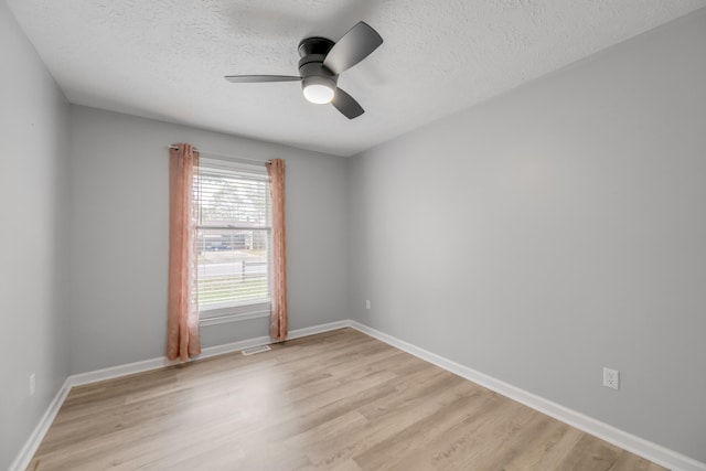 unfurnished room featuring ceiling fan, a textured ceiling, and light wood-type flooring