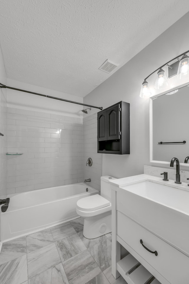 full bathroom with toilet, vanity, tiled shower / bath, and a textured ceiling