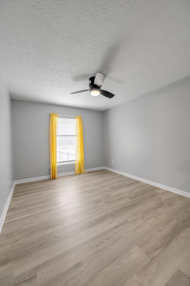 spare room featuring a textured ceiling, ceiling fan, and light hardwood / wood-style flooring