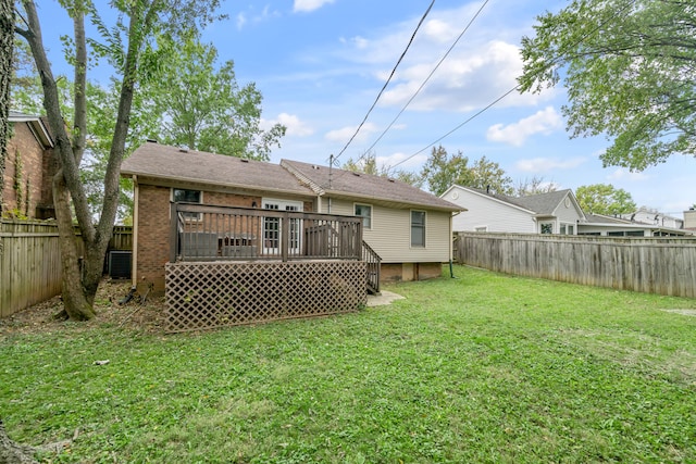 rear view of house with a lawn and a wooden deck