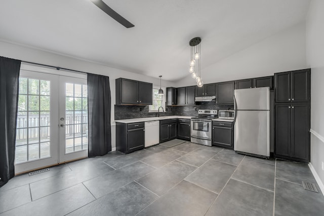 kitchen with pendant lighting, appliances with stainless steel finishes, decorative backsplash, and a wealth of natural light