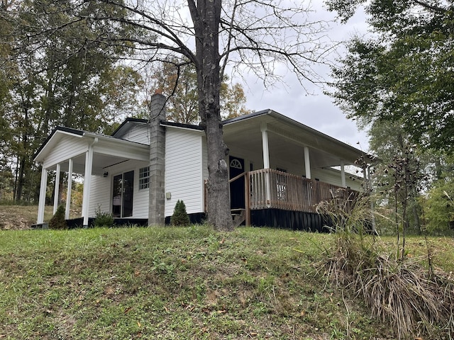 view of side of property with a porch and a chimney