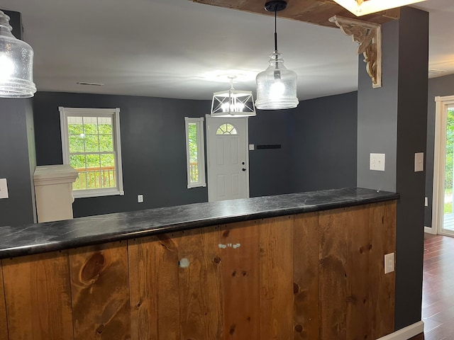 bar featuring a notable chandelier, hardwood / wood-style flooring, and hanging light fixtures