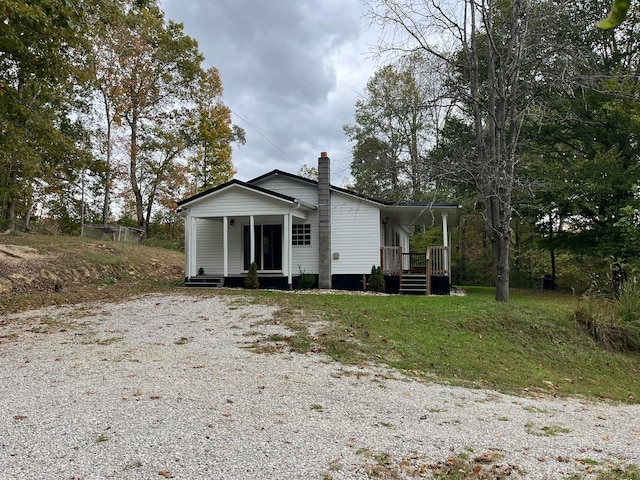 exterior space with a chimney and gravel driveway