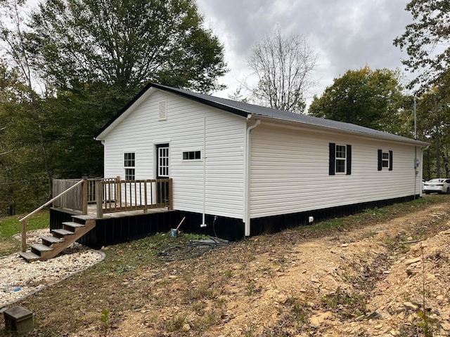 view of side of property with a deck and metal roof